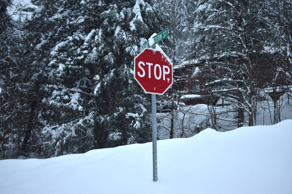 Dense, wet snowpack piles up beneath a stop sign on Great Western street. (Mari Kanagy / Juneau Empire)