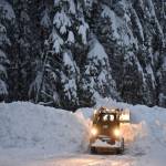 A skid steer engulfed adds to a berm of snow on Dec. 31, 2025. (Mari Kanagy / Juneau Empire)