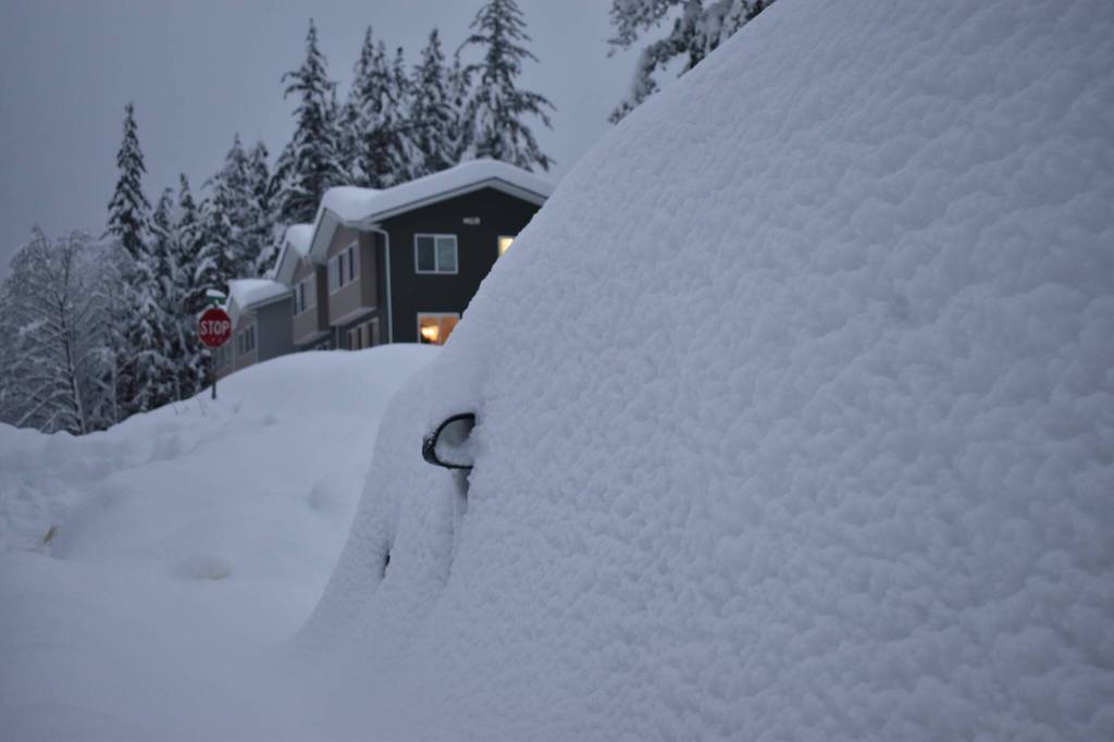 A car engulfed in snow has only its side mirrors exposed Dec. 31, 2025. (Mari Kanagy / Juneau Empire)