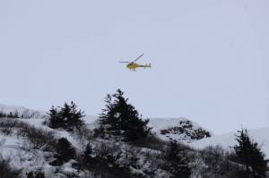 The Alaska Department of Transportation and Public Facilities drops explosives via helicopter to trigger controlled avalanches above Thane Road in February 2023. (Clarise Larson / Juneau Empire file photo)