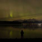 Juneau Empire reporter Mari Kanagy watches the northern lights dance over the Mendenhall Valley from the North Douglas launch ramp late Monday, Jan. 19. (Chloe Anderson/Juneau Empire)