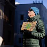 Jeff Wilson holds a sign reading We only have one Earth, dont burn it during a protest led by the Juneau-Douglas High School: Yadaa.at Kalé chapter of Alaska Youth for Environmental Action outside the Alaska State Capitol on Saturday, Jan. 24, 2026. (Chloe Anderson / Juneau Empire)