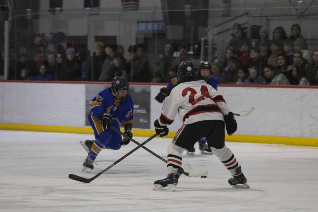 JDHS senior Isaac Phelps guards Mariners freshman Cameron Fox in front of a packed Treadwell Arena on Friday, Jan. 23, 2026. (Chloe Anderson / Juneau Empire)