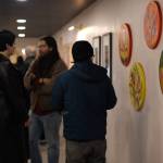 Exhibition attendees admire paintings by Tlingit artist Ursula Hudson during the opening night of Gestures of Our Rebel Bodies at Aan Hít on Jan. 24, 2026. (Chloe Anderson/Juneau Empire)
