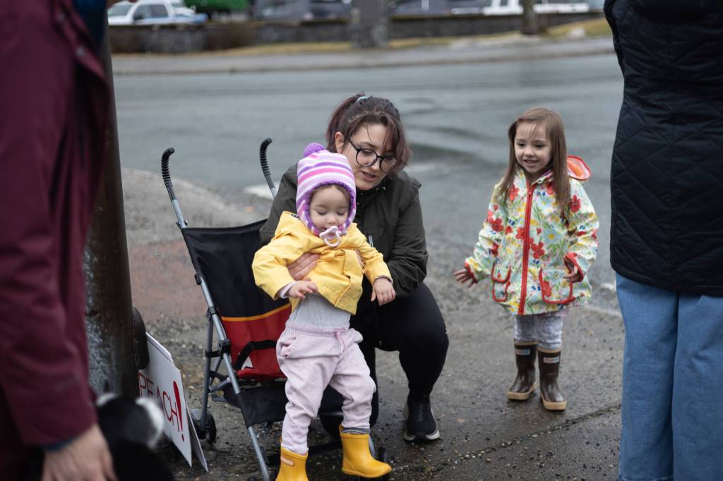 Alyssa Beckley and her two daughters participate in a peaceful protest outside Senator Lisa Murkowskis Juneau office on Feb. 4, 2026. (Chloe Anderson/Juneau Empire)