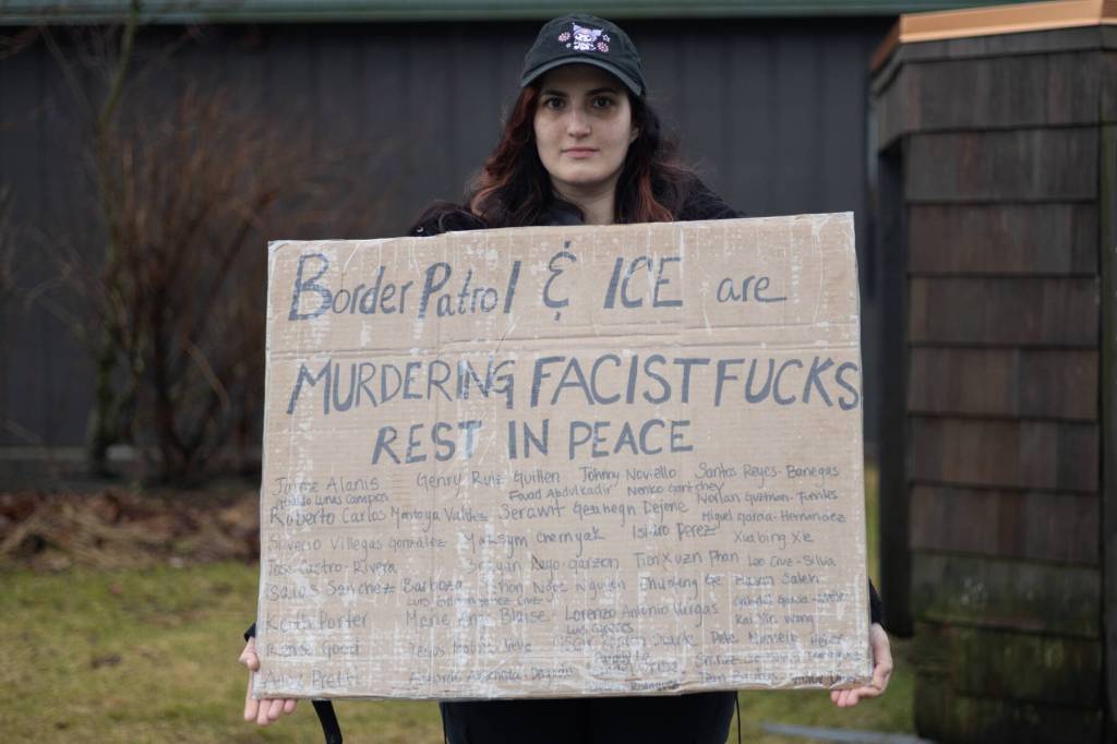 Eleanor Burgess holds a homemade sign with the names of the dozens of people who have died while in ICE custody. A group of 10 Juneauites gathered outside Senator Lisa Murkowskis Juneau office on Feb. 4, 2026 to hold a peaceful discussion with Senate staff. (Chloe Anderson/Juneau Empire)