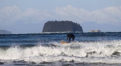 Surfer catches wave at Lena Cove. (Photo by Atticus Hempel/Juneau Empire)
