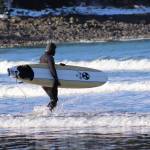 Surfer walks into the water around 10am. (Photo by Atticus Hempel/Juneau Empire)