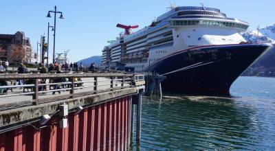 Tourists walk along Juneaus harbor on April 26, 2024, next to the docked Carnival Spirit, a ship operated by Carnival Cruise Line. (Yereth Rosen/Alaska Beacon)