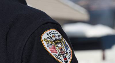 A Juneau police officer stands on duty in early March. (Clarise Larson/Juneau Empire File)