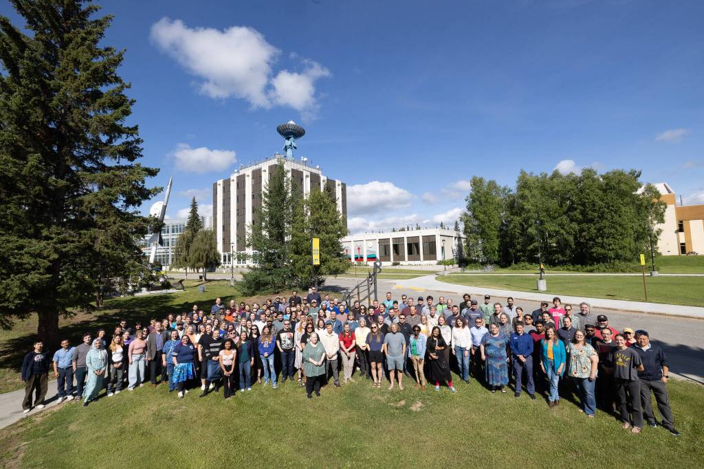 Geophysical Institute faculty, staff and student researchers gather in 2025 for a group photo with the institutes antenna-topped home building in the background. (Photo by Bryan Whitten)